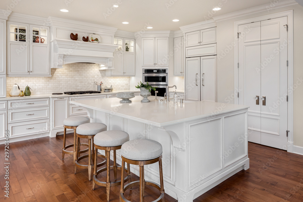 Beautiful kitchen in new traditional style luxury home, with large island, double ovens, cook top, and open concept floor plan - obrazy, fototapety, plakaty 
