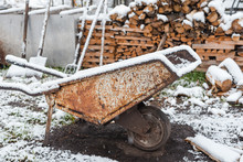 Garden Car Under The Snow. Garden Tools In The Winter. Rusty Garden Car.
