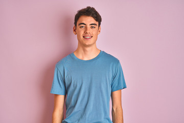 teenager boy wearing casual t-shirt standing over blue isolated background with a happy and cool smi