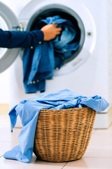 Close up washing machine and clothes in basket on white background. Laundry concept.