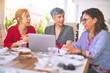 © Krakenimages.com - Meeting of middle age women having lunch and drinking coffee. Mature friends smiling happy using laptop at home on a sunny day
