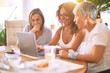 © Krakenimages.com - Meeting of middle age women having lunch and drinking coffee. Mature friends smiling happy using laptop at home on a sunny day