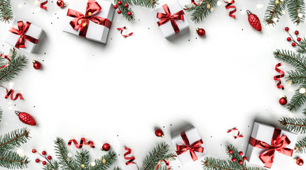 Wall Mural - creative frame made of christmas fir branches, gift boxes, red decoration, sparkles and confetti on 