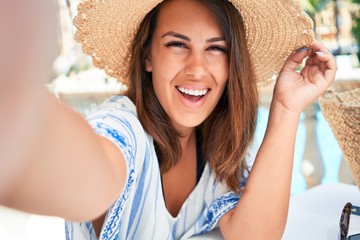 Young beautiful woman taking selfie with smartphone smiling happy enjoying sunny day of summer at hotel resort on holidays