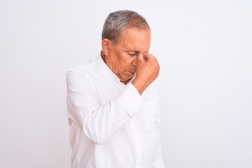 Sticker - Senior grey-haired man wearing elegant shirt standing over isolated white background tired rubbing nose and eyes feeling fatigue and headache. Stress and frustration concept.