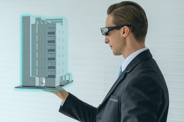 Wall Mural - smart glasses device technology concept, engineering hold the building with use augmented mixed virtual reality with artificial intelligence technology to see the 3d model ,