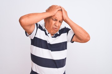 Canvas Print - Senior grey-haired man wearing casual striped polo standing over isolated white background suffering from headache desperate and stressed because pain and migraine. Hands on head.