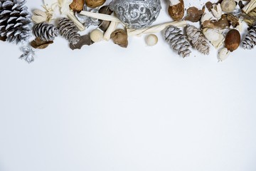 Canvas Print - Overhead shot of a white surface with pine cones and an ornament on the top