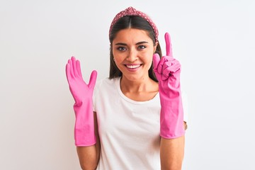 Wall Mural - Young beautiful woman wearing clean gloves standing over isolated white background surprised with an idea or question pointing finger with happy face, number one