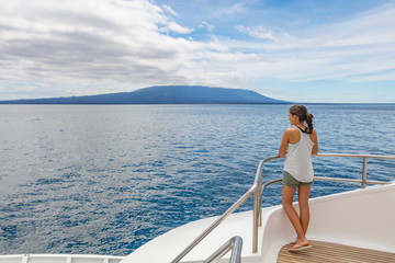 Wall Mural - Cruise ship tourist on luxury yacht looking at sea nature landscape in Galapagos Islands while sailing on boat enjoying luxury travel lifestyle.