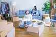 © Krakenimages.com - Young beautiful couple sitting on the sofa drinking cup of coffee at new home around cardboard boxes