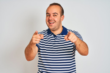 Sticker - Young man wearing casual striped polo standing over isolated white background pointing to you and the camera with fingers, smiling positive and cheerful