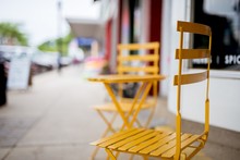 Closeup Of A Yellow Chair Near A Shop On The Sidewalk