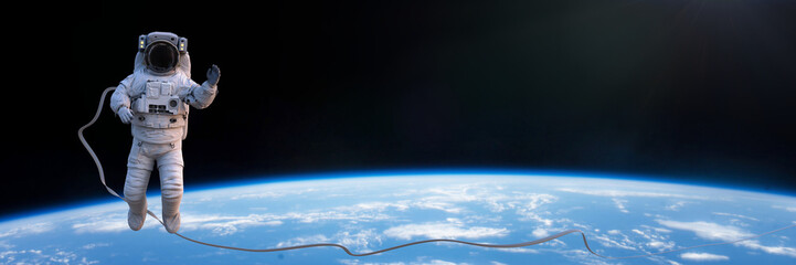 Wall Mural - astronaut in spacesuit during spacewalk above planet earth