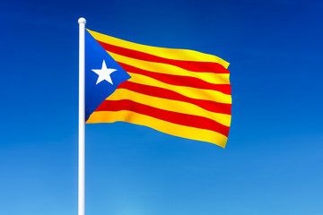Wall Mural - Waving flag of Catalonia on the blue sky background