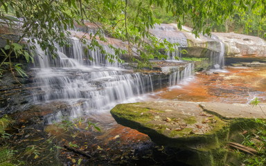 Pen Pob Waterfall, beautiful white water flowing on rock cliff around with green forest background, Phu Kradueng National Park, Loei, Thailand.