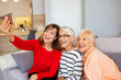 © Dragana Gordic - Beautiful senior women having fun taking selfies at home. Senior friends using a Phone. Senior women having fun with smartphone making selfies. Capturing their friendship