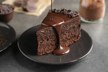 Pouring Chocolate Sauce Onto Delicious Fresh Cake On Grey Table, Closeup