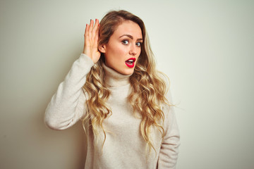 Sticker - Beautiful woman wearing winter turtleneck sweater over isolated white background smiling with hand over ear listening an hearing to rumor or gossip. Deafness concept.