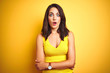 © Krakenimages.com - Young beautiful woman wearing t-shirt standing over yellow isolated background afraid and shocked with surprise expression, fear and excited face.