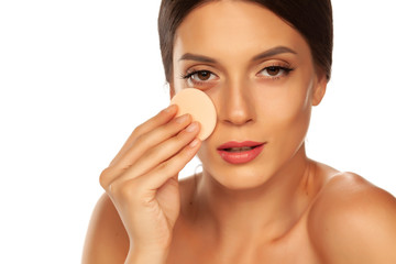 Poster - Young beautiful woman claning her face with cotton pad on white background