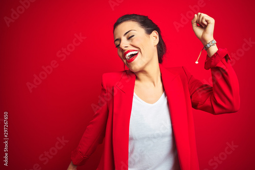 Fotomural Young beautiful business woman standing over red isolated background Dancing hap