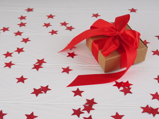 Wall Mural - gift box with bright red pink ribbon on white background with stars. space for text to postcard