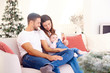 © gzorgz - Lovely family with their baby girl relaxing on sofa at home during Christmas