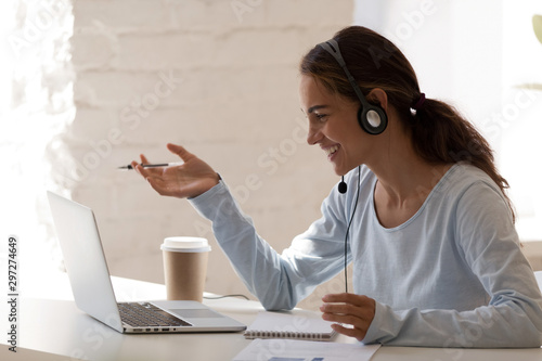 Fotomural Smiling millennial lady freelancer wearing headset, communicating with client
