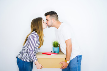 Poster - Young beautiful couple holding cardboard box over isolated white background