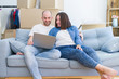 © Krakenimages.com - Young couple sitting on the sofa at new home using computer laptop, smiling happy for moving to a new apartment