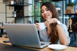 © chayathon2000 - Asian woman working and drink coffee in cafe with laptop computer smile and happy work