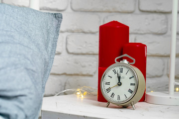 Wall Mural - Metal vintage alarm clock standing on the nightstand near the bed close-up