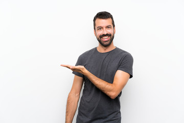 Wall Mural - Young handsome man over isolated white background presenting an idea while looking smiling towards
