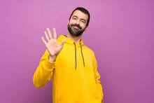 Handsome Man With Yellow Sweatshirt Counting Five With Fingers