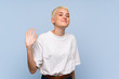 © luismolinero - Teenager girl with white short hair over blue wall saluting with hand with happy expression