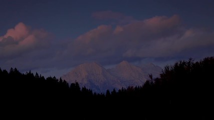 Wall Mural - timelapse of mountain view of alpine peaks and forest and sunset sky