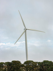 Wall Mural - a large wind turbine moving to create kinetic energy for renewable energy supply on a cloudy day loc