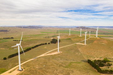 Wall Mural - aerial view of large wind turbines moving to create kinetic energy for renewable energy supply on a 