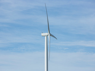 Wall Mural - close up of a large wind turbine moving to create kinetic energy for renewable energy supply on a cl
