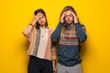 © luismolinero - Hippie couple over yellow background unhappy and frustrated with something