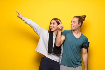 Group of athletes over yellow background pointing away