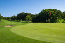 Panorama View Of Golf Course With Beautiful Putting Green. Golf Course With A Rich Green Turf Beautiful Scenery.