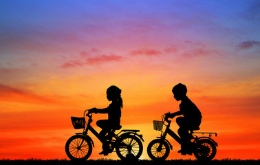 Sticker - silhouette happy children  ride bike on sunrise