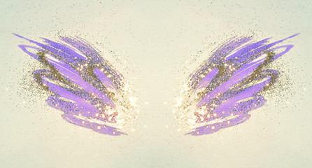 Golden glitter on abstract purple watercolor wings in vintage nostalgic colors.