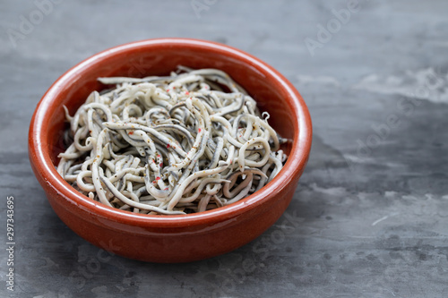 Fotomural Traditional Spanish food. Gulas with oil in ceramic dish.