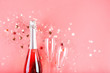 Christmas concept. Pink champagne, sparkles and a pair of glasses.