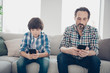 © deagreez - Do not leave in virtual life spend time with your relatives concept. Photo of serious kid and his bearded in checkered shirt dad holding telephones in hands typing request on internet watch video