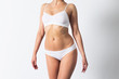 © maxsim - Slim figure of a woman in underwear on white background.