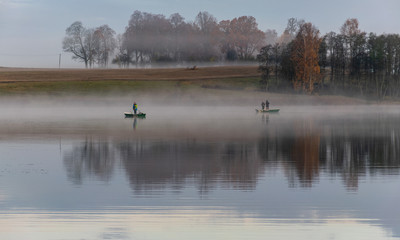 Wall Mural - early autumn morning, white mist over water and ground, beautifully colored and blurred tree silhouettes in the background